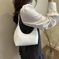 Minimalist white patent leather shoulder bag with glossy finish shown on model - White