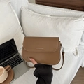 Borsa a sella in pelle marrone con chiusura a patta e scritta logo bianca elegante - Marrone