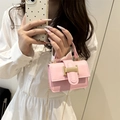 Pink mini crossbody bag with gold chain strap and metal clasp worn with white dress - Light Pink