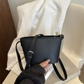 Minimalistische schwarze Leder-Eimertasche mit geprägten Buchstaben und Riemen - Schwarz