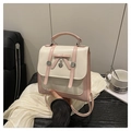Close-up van een roze en beige rugzak met strik, hartvormige hanger en FASHION-logo - Wit en Roze