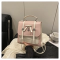 Detail van roze en beige leren rugzak met witte strik en hartvormige metalen hanger - Kersenbloesem Roze