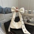 Schicke cremefarbene Handtasche mit großer Schleife, silbernen Nieten und Glanzoptik - Weiß