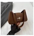 Close-up of brown leather underarm bag with silver star-shaped metal buckle and flap - Brown