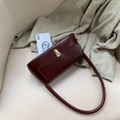 Minimalist dark reddish brown rectangular underarm bag with gold clasp on white chair - Tan