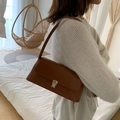 Brown rectangular leather underarm bag with silver metallic buckle on a white knit sweater - Dark Brown