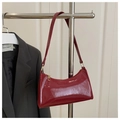 Detail of burgundy patent leather shoulder bag with glossy stone texture and gold zipper - Glossy Red