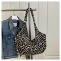 Dettaglio della borsa hobo con stampa leopardata in tela appesa vicino a una giacca - Stampa leopardata / Stampa leopardata