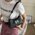 Classic black leather shoulder bag with a stylish silver metal bow detail on the flap - Black