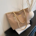 Beige shopper met reliëfletterpatroon en lange hengsels in een minimalistische setting - Khaki