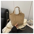 Detail view of beige bucket bag with lychee grain texture and golden metal hardware - Khaki