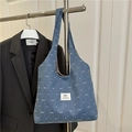 Blauwe denim shopper met witte strikjes hangend aan een rek voor een zwarte blazer - Zonder Hanger / Donkerblauw
