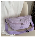 Detalle de riñonera de nailon plisado lavanda con logo metálico y cremallera triangular - Morado