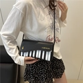 Elegante borsa a tracolla con motivo a tasti di pianoforte e dettaglio nota d'oro - Nero