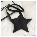 Flat lay of star-shaped black canvas crossbody bag with broad strap on white fabric - Black