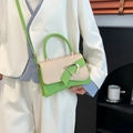Green leather and beige woven fabric small crossbody bag with gold D-buckle shown on model - Orange