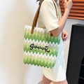 Gewebte Strandtasche mit grünem Zickzackmuster und Summer-Stickerei an einem Modell - Grün