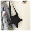 Dettaglio della borsa a tracolla a stella in nylon nero appesa a una giacca di jeans - Nero