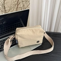 Beige nylon crossbody bag with textured fabric and adjustable strap on a minimalist desk - Khaki