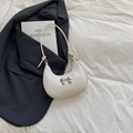 Weiße geflochtene Crescent-Tasche mit silberner Schleife in modischem Setting - Weiß