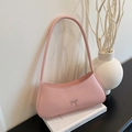 Pink matte leather underarm baguette bag featuring a decorative metal bow detail - Pink