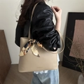 Schicke beige Tragetasche mit Seidenschal-Griff am Modell für einen modernen Look - Khaki