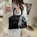 Bolso tipo concha de charol negro brillante con lazo de encaje blanco y asa elegante - Negro