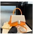 Detailansicht der orangefarbenen Ledertasche mit beiger Webstruktur und goldenem Drehverschluss - Orange