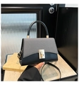 Detailansicht der Handtasche mit schwarzem Leder und gewebter Klappe in Kontrastfarbe - Schwarz
