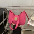 Rose pink crescent underarm bag with gold rivet clasp and shoulder strap on a sleek stand - Rose Pink