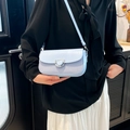 Piccola borsa quadrata vintage celeste con tracolla e fibbia in metallo indossata da modella - Blu
