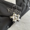 Silver flower metal mini chain bag with pearl detail on black suit jacket backdrop - Silver