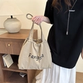 Beige canvas drawstring tote bag with black Fanyisa logo in a cozy interior scene - Khaki