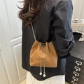 Caramel bucket bag with crocodile texture and butterfly hardware in crossbody view - Brown