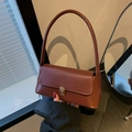 Retro braune Schultertasche aus Leder mit Goldverschluss in Lifestyle-Umgebung gezeigt - Kaffeebraun