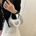 Borsa a mano argento metallizzato con applicazione cuore in pizzo indossata da modella - Argento