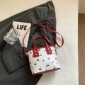 Detail van mini bucket bag met kersenprint, rode leren handvatten en goudkleurige gesp - Rood (Geen Hanger)
