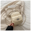 Detail of cream quilted mini backpack featuring chain straps and silver twist-lock closure - Yellow