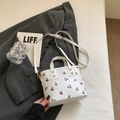 Witte leren draagtas met rode kersenpatronen en gouden details op grijze blazer - Wit Zonder Hanger