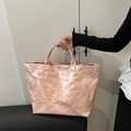 Pink textured tote bag with TOTE BAG print held by a model for a casual summer style - Pink