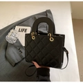 Détail du sac à main matelassé noir avec poignée ronde et finitions métalliques dorées - Noir