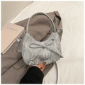 Detail of silver pleated crescent bag with bow decoration and metallic brand logo - Silver