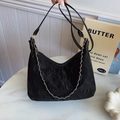 Bolso tote negro plisado minimalista con cadena dorada en un entorno elegante - Negro