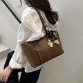 Dark brown leather tote bag with elegant printed silk scarf on handle, shown on model - Dark Brown