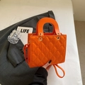 Helle orangefarbene gesteppte Handtasche mit Griff und goldenen Metallbeschlägen für Damen - Orange