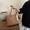 Brown leather tote bag with a patterned scarf and V-cut top in a casual setting - Tan