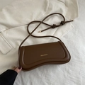 Brown vintage faux leather baguette bag with gold logo on textured aesthetic background - Brown