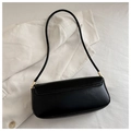 Detailed top view of a black minimalist baguette bag with fine stitching on a white fabric - Black