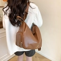 Großer brauner Damen Rucksack aus PU-Leder mit Falten-Design getragen von einem Model - Braun