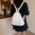 Minimalistischer weißer Faltenrucksack mit Reißverschlussfach in einem modernen Café - Weiß